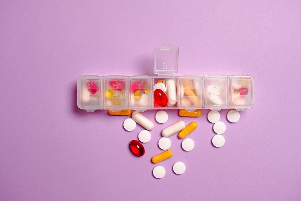 Symbolbild einer Tablettendosierungsschachtel mit verschiedenen Tabletten.
